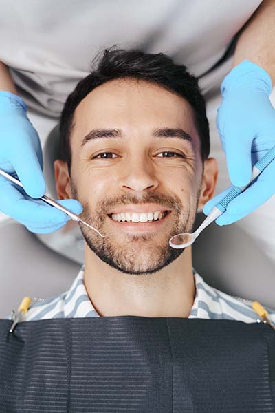 homem contente consultório dentista