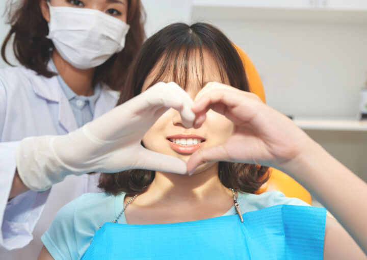 young woman with doctor making heart symbol